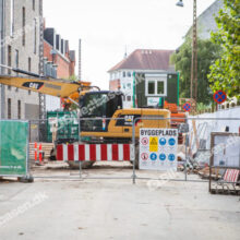 Byggeplads og vejarbejde med stor gravemaskine og henvisning til køretøjer og forgængere